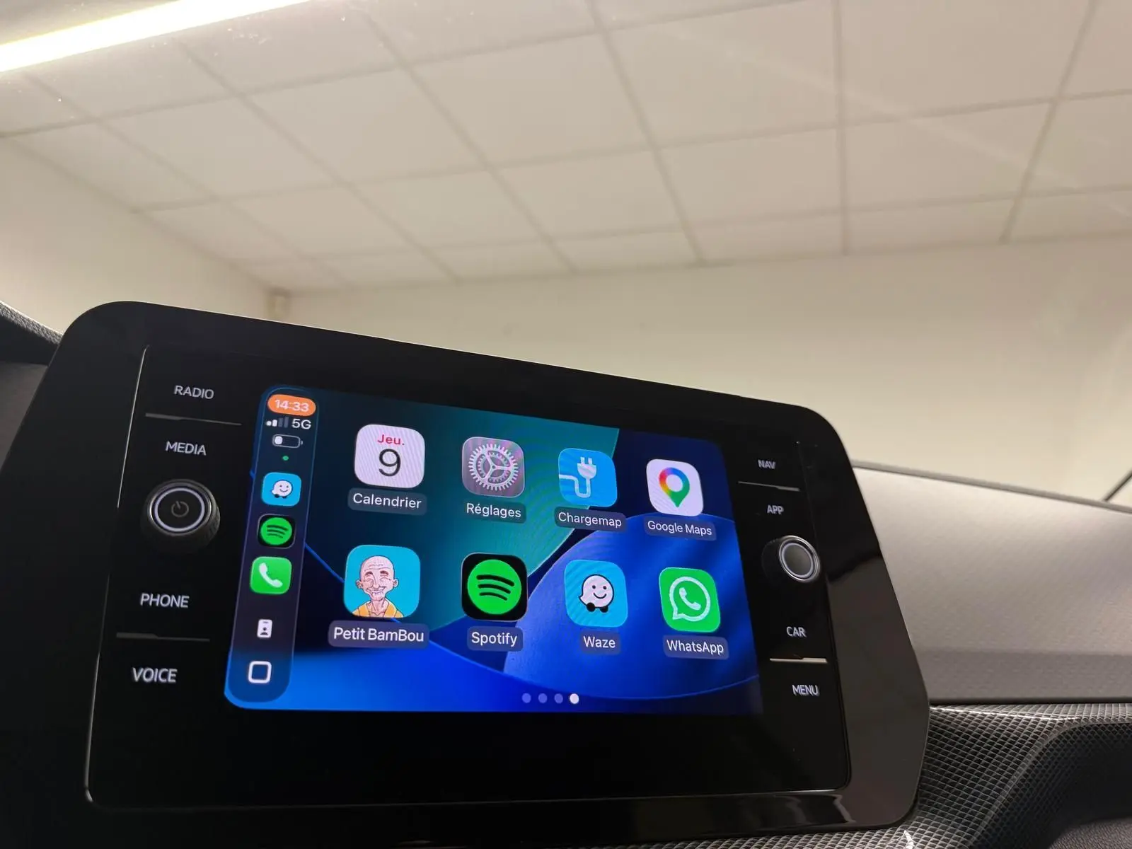 Écran tactile central du Volkswagen T-Cross 2025 affichant plusieurs applications, intérieur gris cendre visible en arrière-plan.