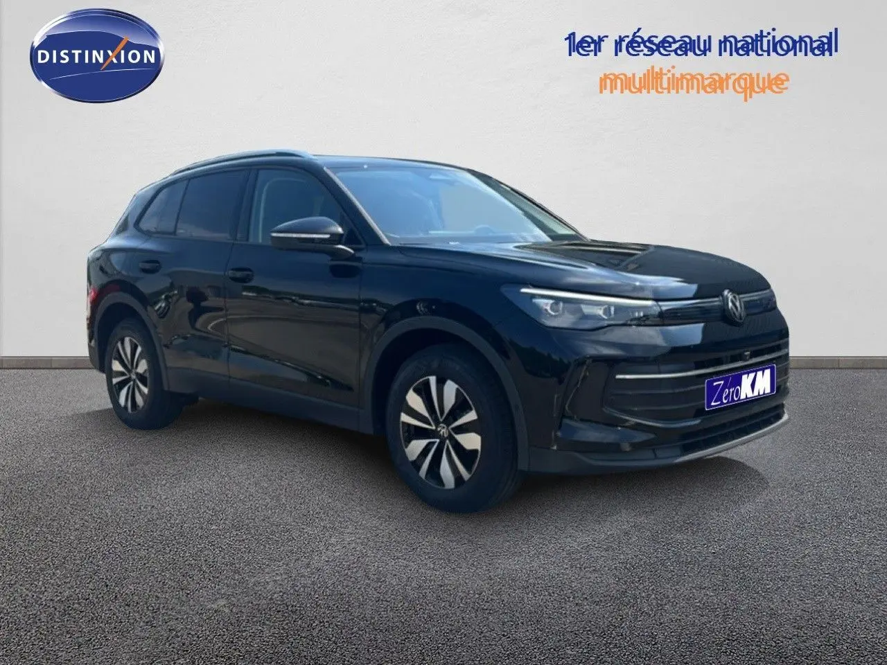 Vue 3/4 avant droit du Volkswagen Tiguan noir Grenadilla métallisé avec jantes spécifiques et calandre épurée.