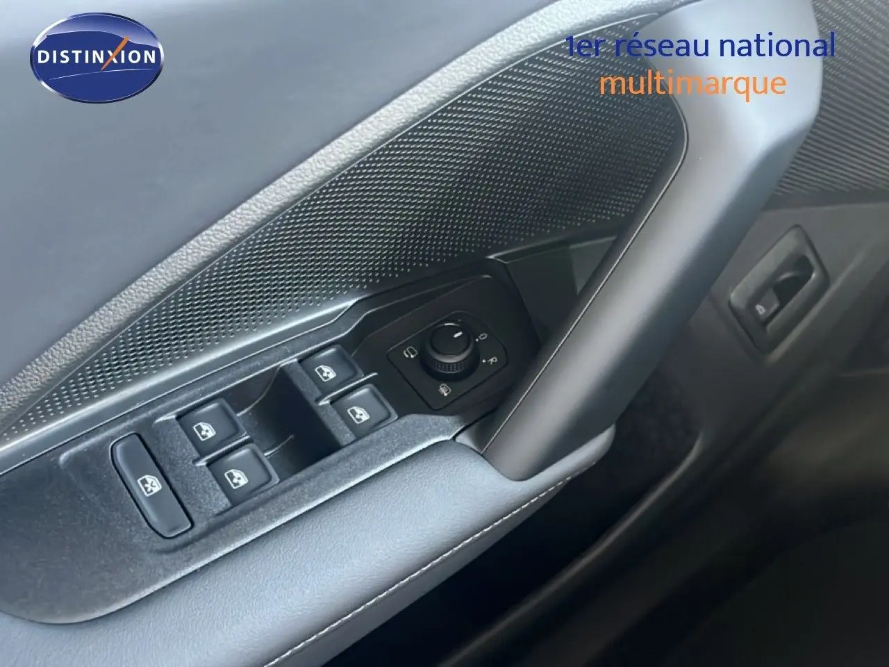 Gros plan sur la commande des vitres et rétroviseurs côté conducteur de la Volkswagen Tiguan noir Grenadilla 2026.