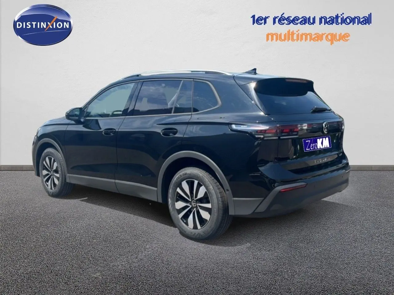 Volkswagen Tiguan noir grenadilla métal en 3/4 arrière droit, avec jantes alliage et toit ouvrant visible.