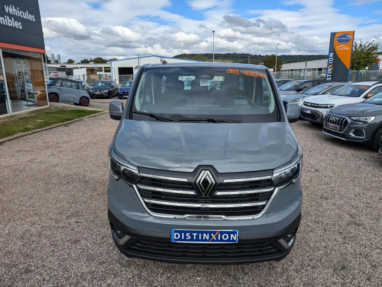 Vue frontale d'un Renault Trafic Fourgon gris 2025 avec calandre chromée et logo Renault bien visible.