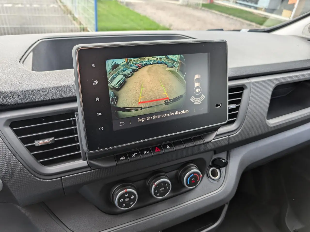 Vue intérieure du tableau de bord du Renault Trafic Fourgon gris 2025, avec écran tactile affichant la caméra de recul.