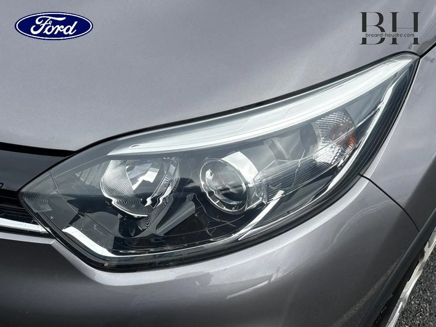 Gros plan sur le phare avant droit du Renault Captur gris Cassiopée, mettant en valeur les détails du bloc optique.