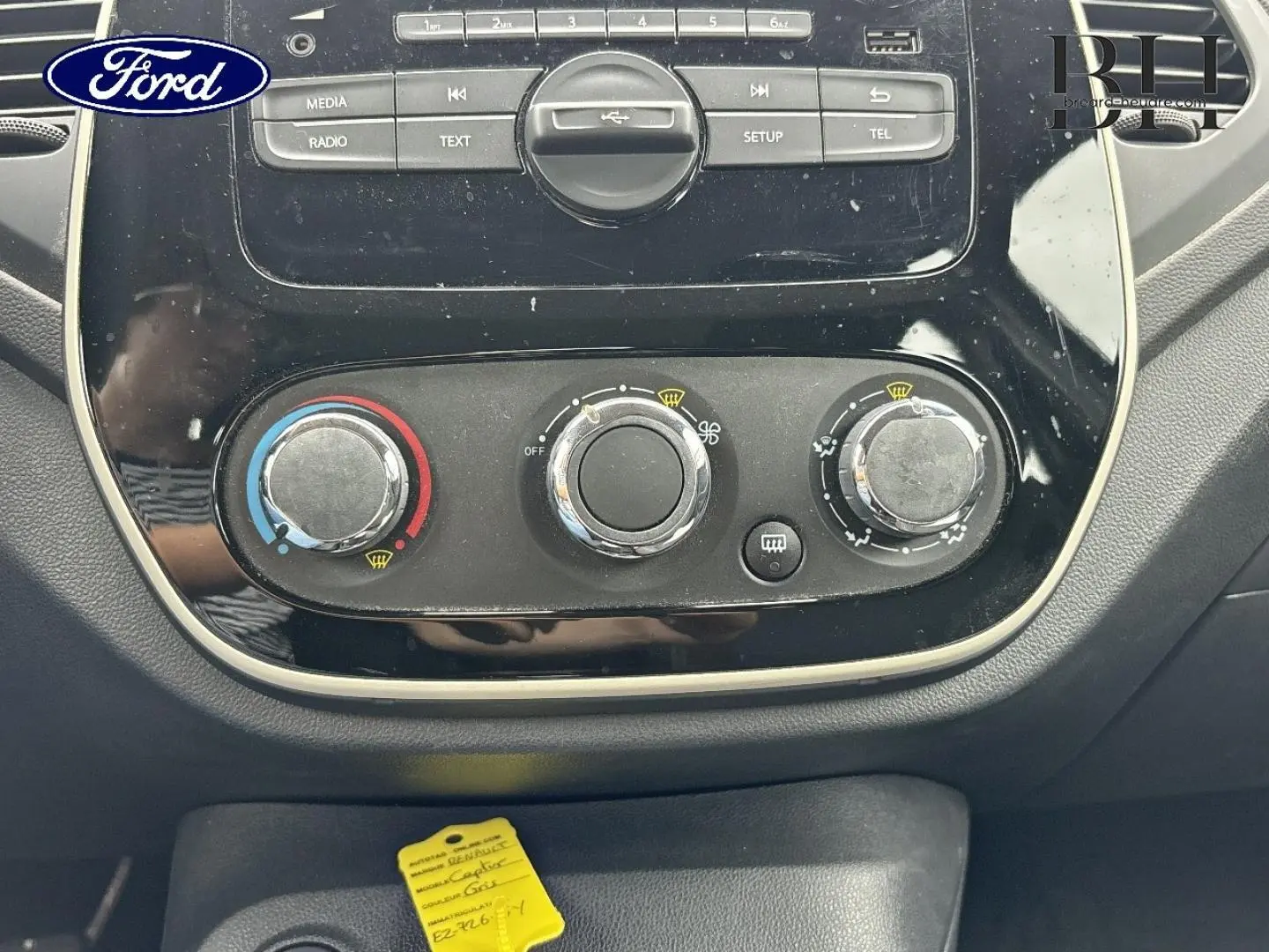 Tableau de bord noir avec commandes manuelles de climatisation du Renault Captur Gris Cassiopée, vue rapprochée frontale.