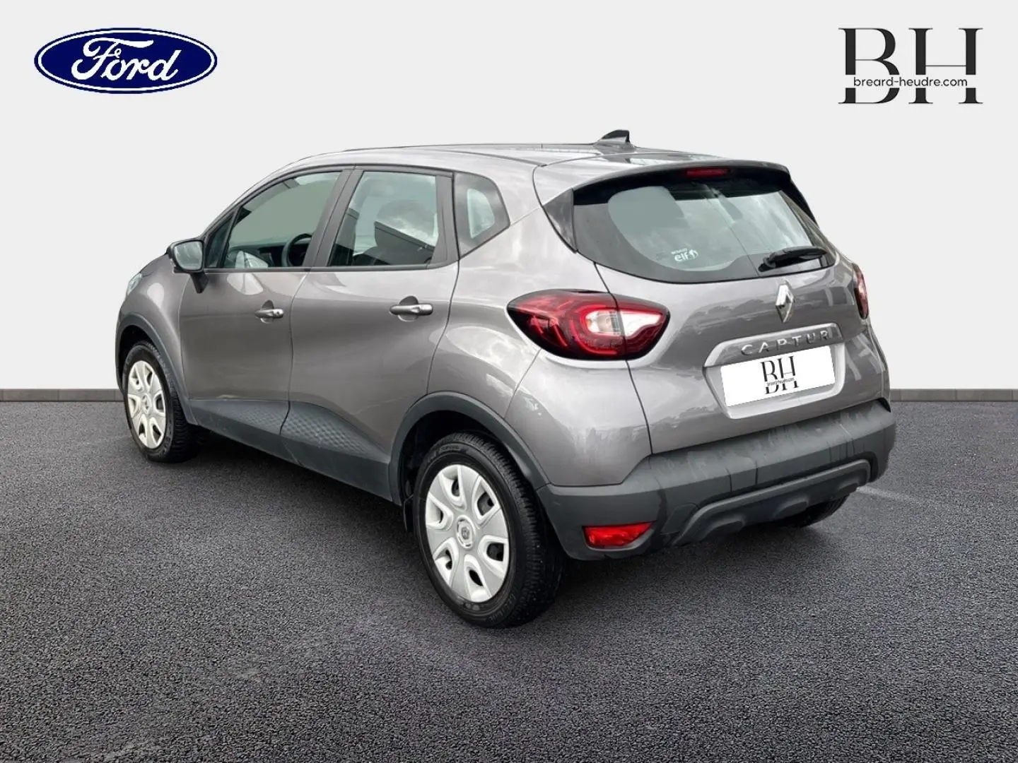 Renault Captur gris Cassiopée vue 3/4 arrière droit, mettant en valeur les feux LED et le becquet arrière.