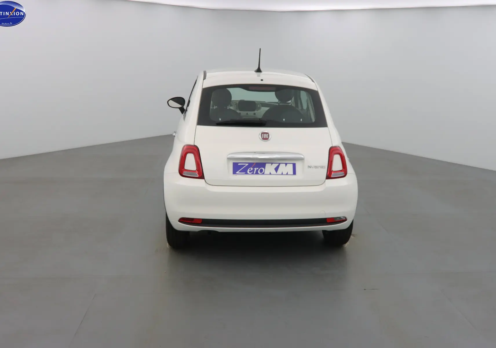 Vue arrière d'une FIAT 500 blanche Gelato 2023 avec logo et badge Hybrid visibles sur un fond neutre.
