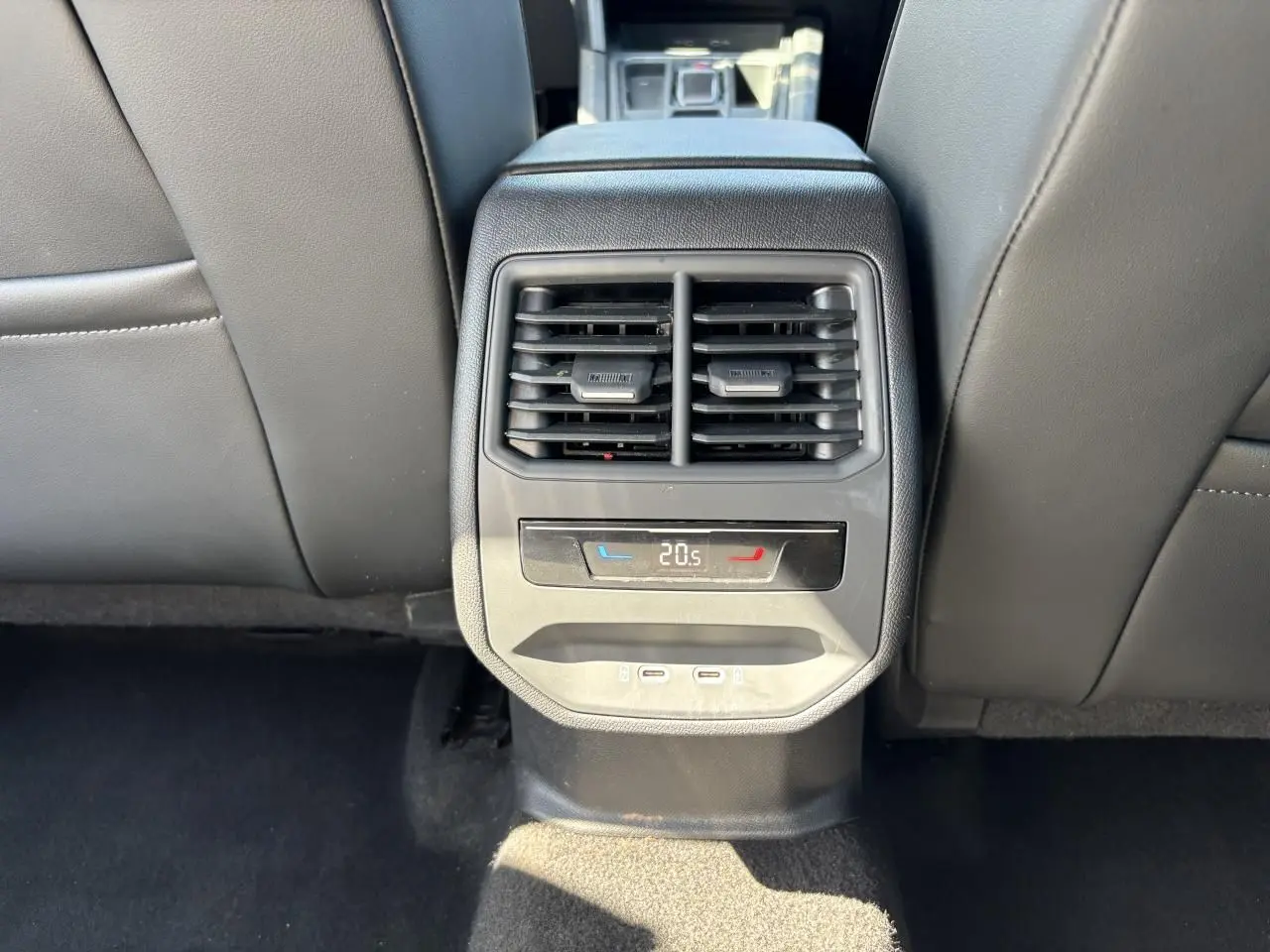 Vue rapprochée de la console centrale arrière avec aérateurs, réglage climatisation à 20,5°C et deux prises USB-C.