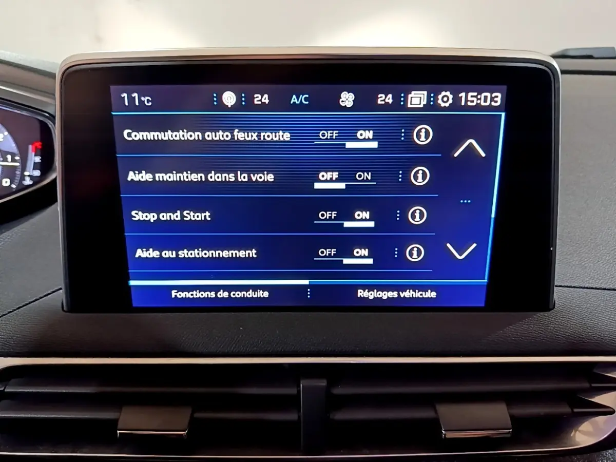 Écran tactile central du tableau de bord du Peugeot 5008 bleu, affichant les aides à la conduite activées.