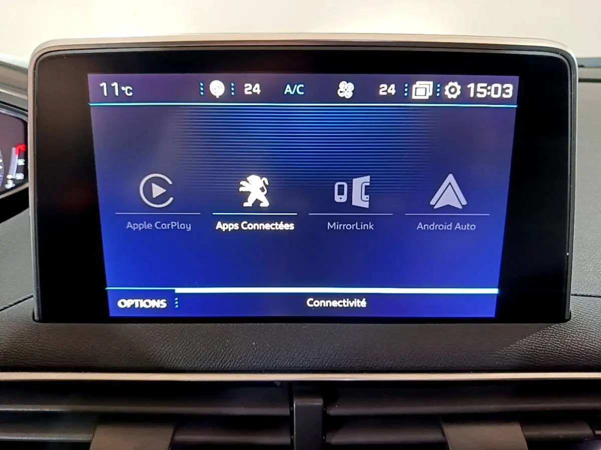 Écran tactile central affichant les options de connectivité Apple CarPlay, MirrorLink et Android Auto dans un Peugeot 5008 bleu.