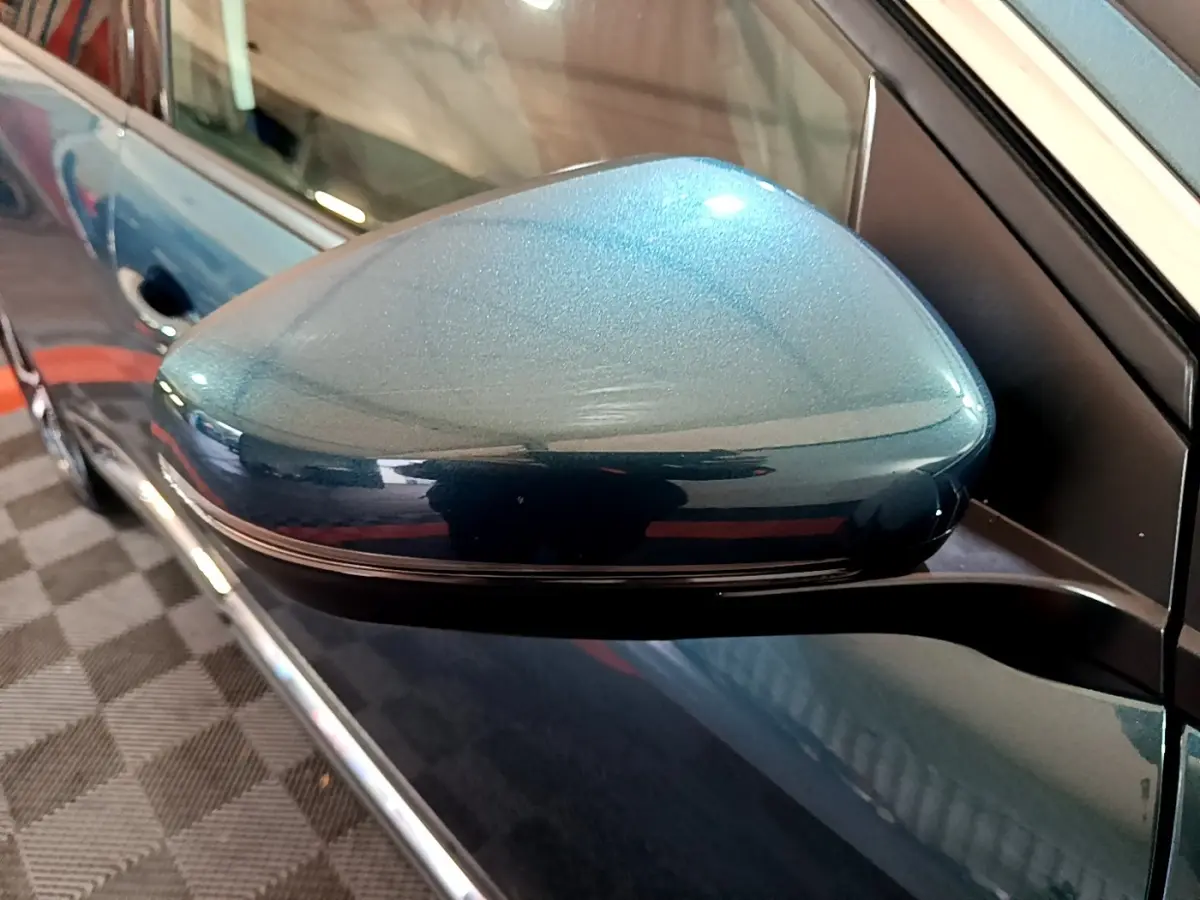 Rétroviseur côté gauche bleu métallisé du Peugeot 5008 2018, avec carrosserie et poignée de porte visibles en arrière-plan.