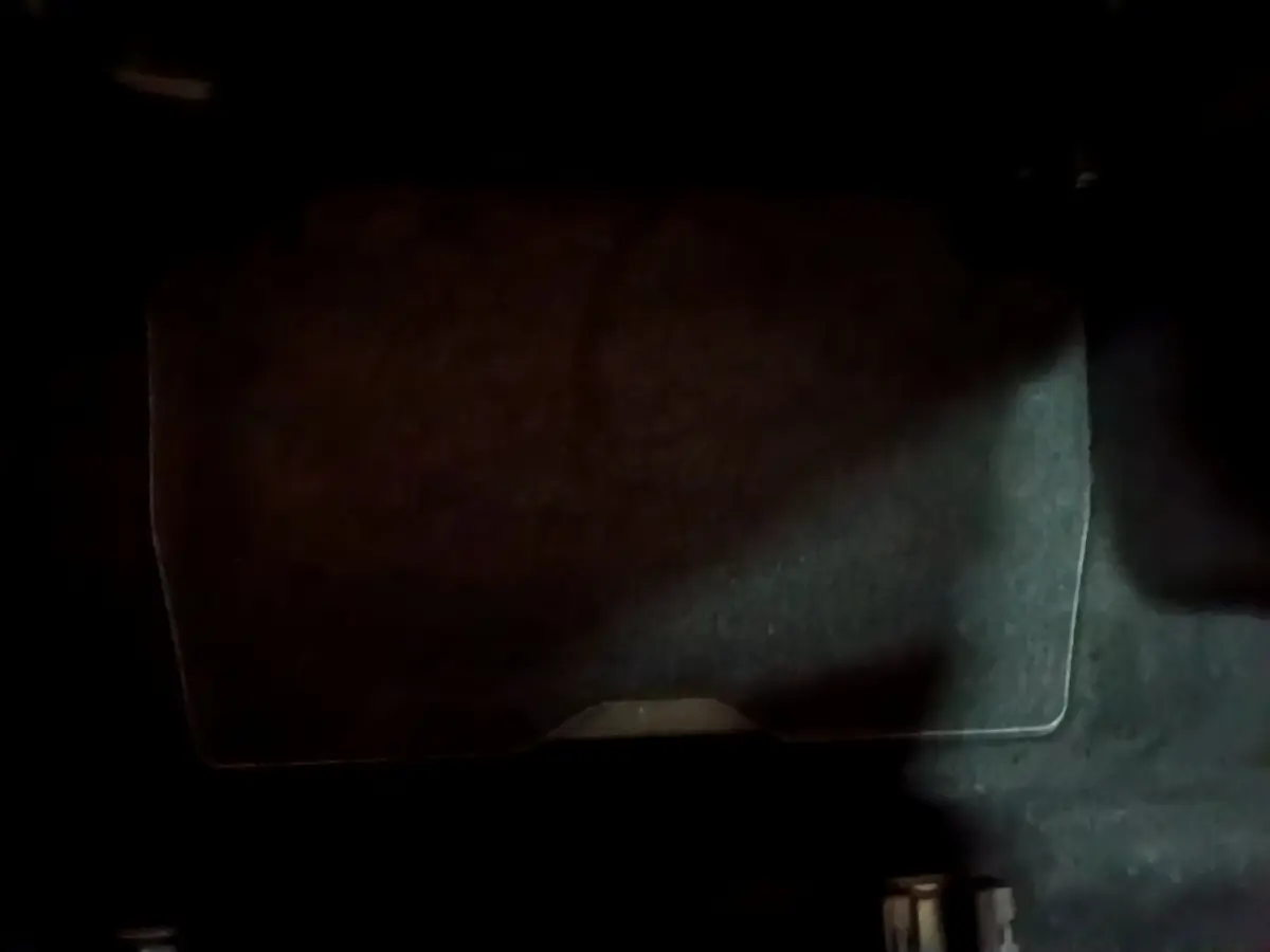 Gros plan sur le coffre avec plancher plat et tapis noir du Peugeot 5008 bleu vue intérieure arrière