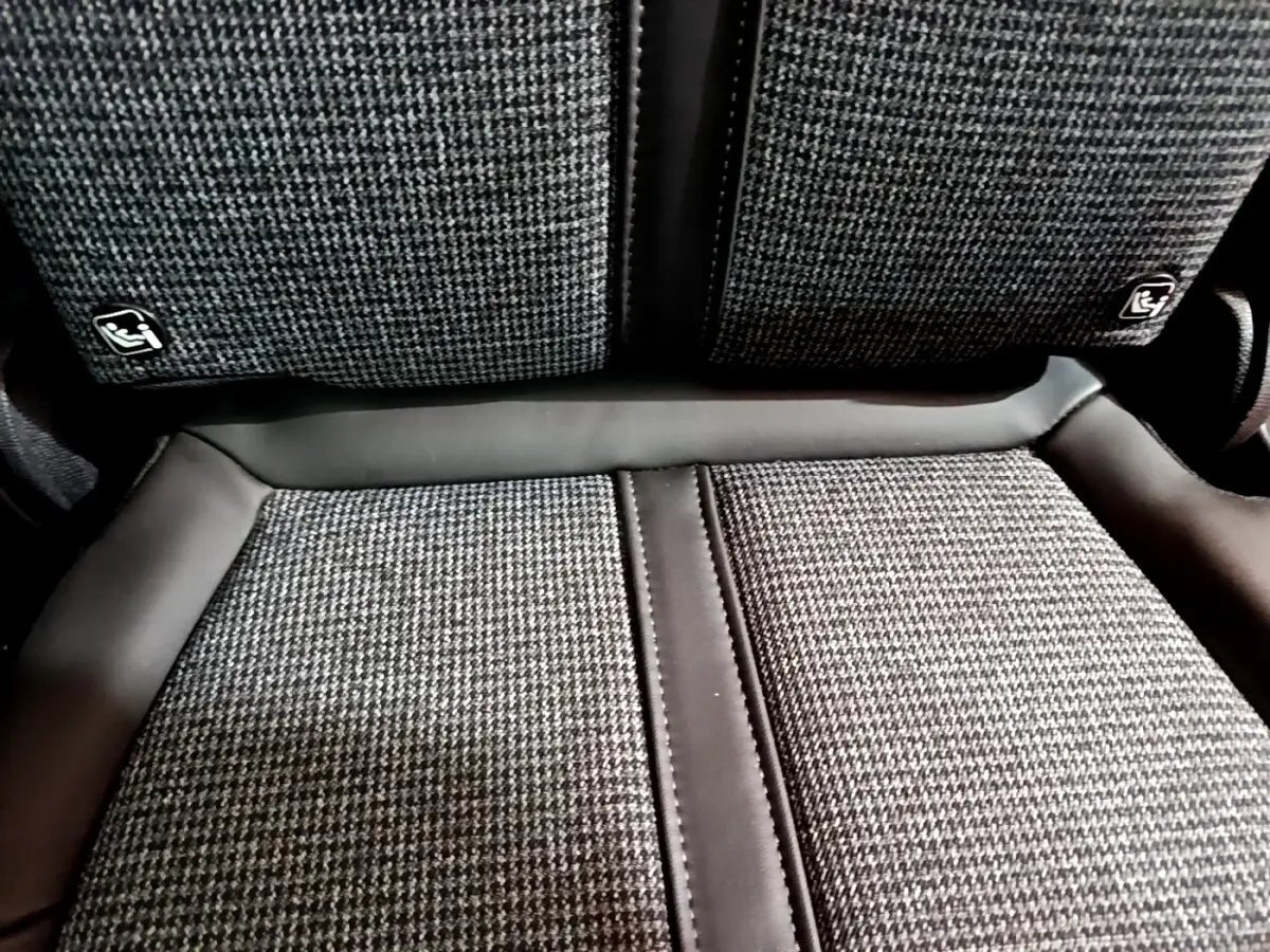 Gros plan sur la banquette arrière tissu gris et cuir noir du Peugeot 5008 Allure 2018, avec fixation Isofix visible.