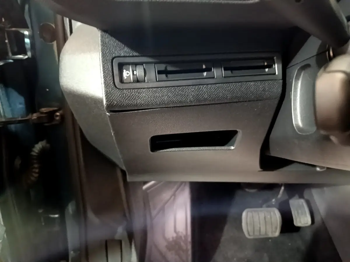 Vue intérieure côté gauche du Peugeot 5008 bleu 2018, montrant la commande des phares et les pédales.