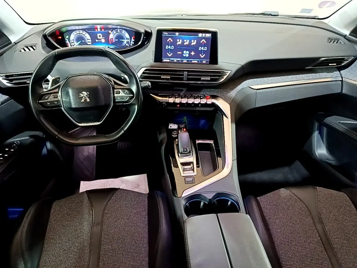 Vue intérieure avant du Peugeot 5008 bleu 2018, tableau de bord avec écran tactile et volant compact cuir multifonctions.