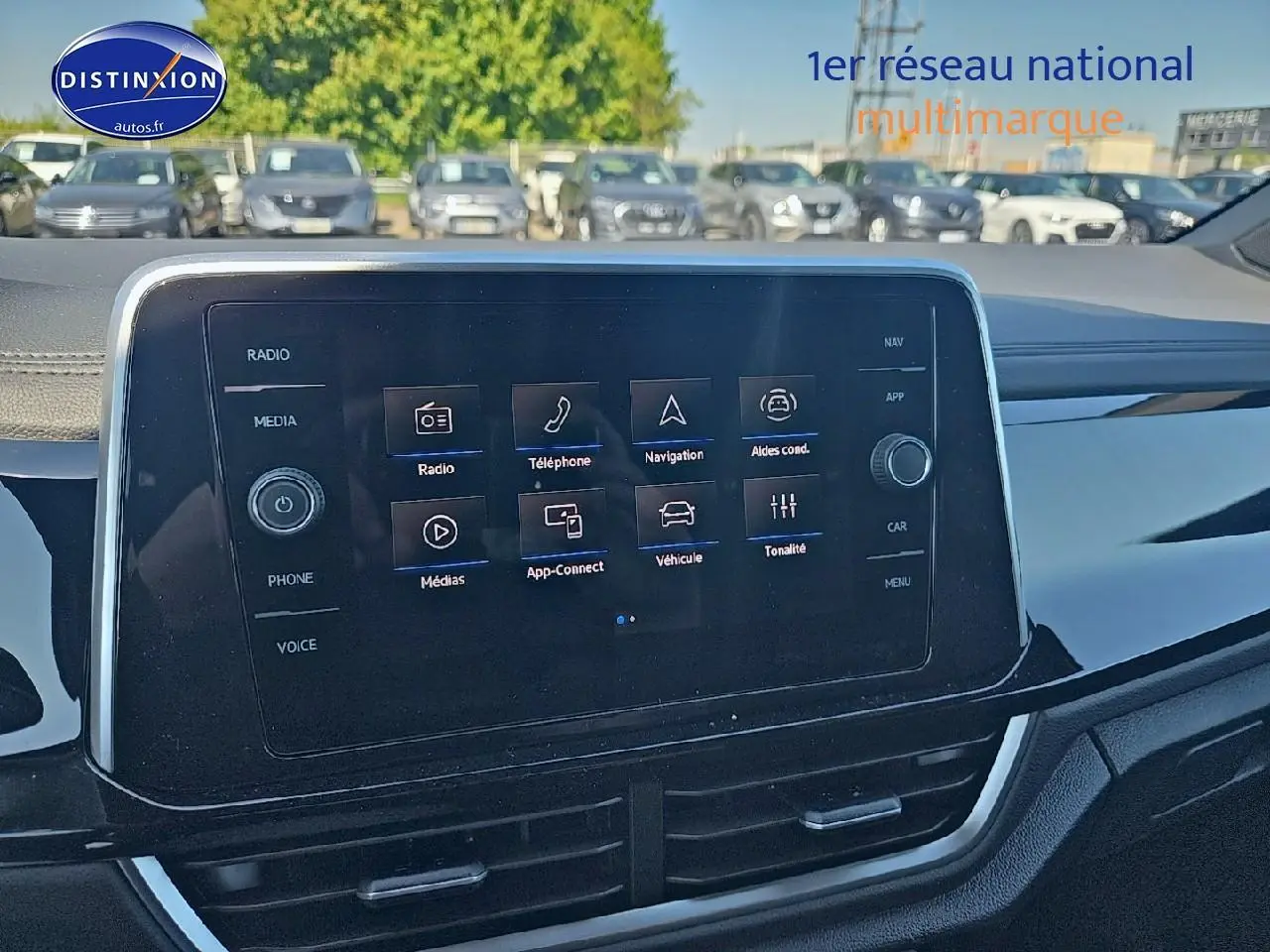 Vue intérieure centrée sur l’écran tactile multifonction du Volkswagen T-Roc noir perle, avec tableau de bord moderne.