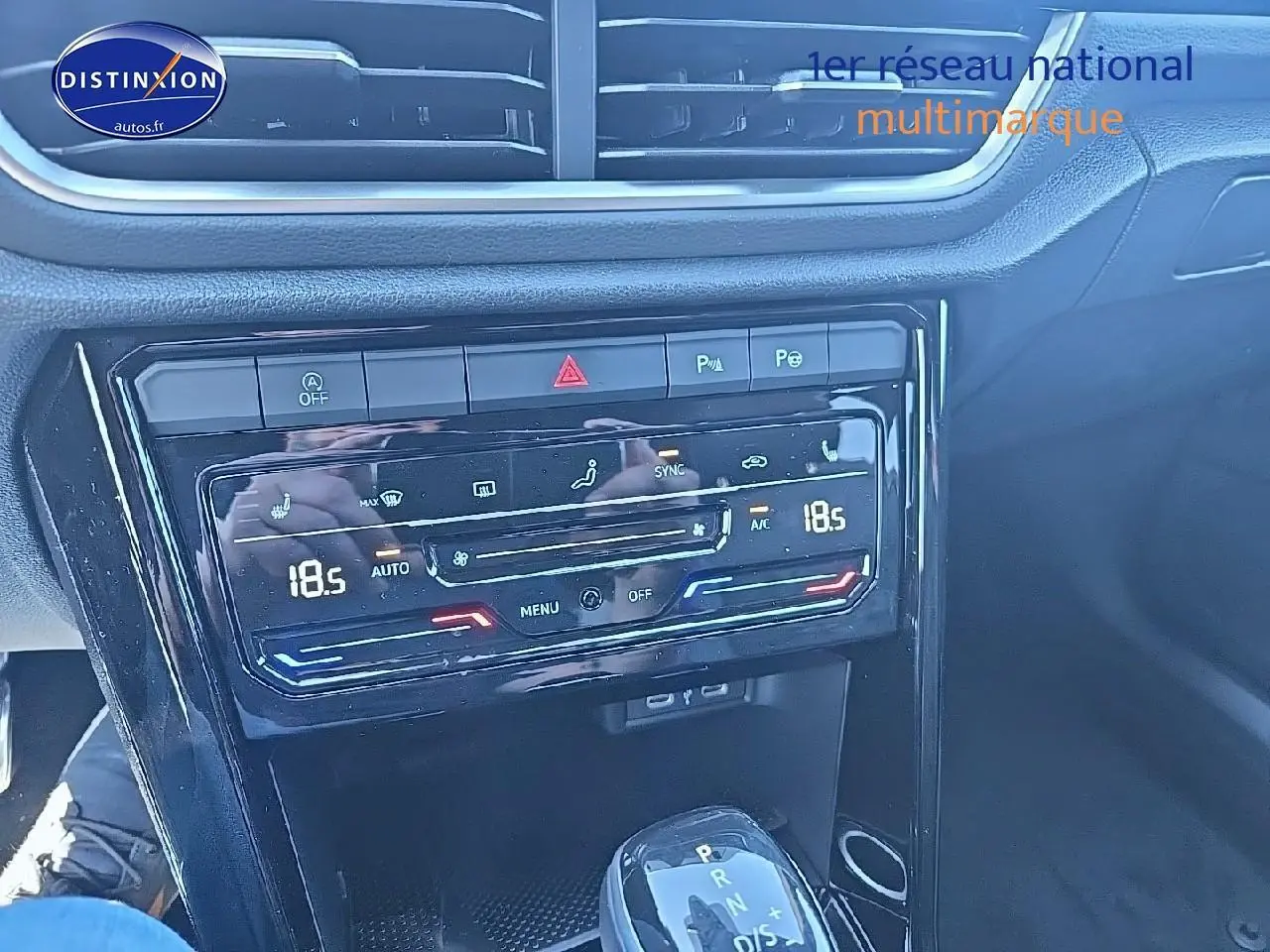 Gros plan sur la console centrale du Volkswagen T-Roc noir perle 2025, mettant en valeur la climatisation digitale et le levier de vitesse automatique.