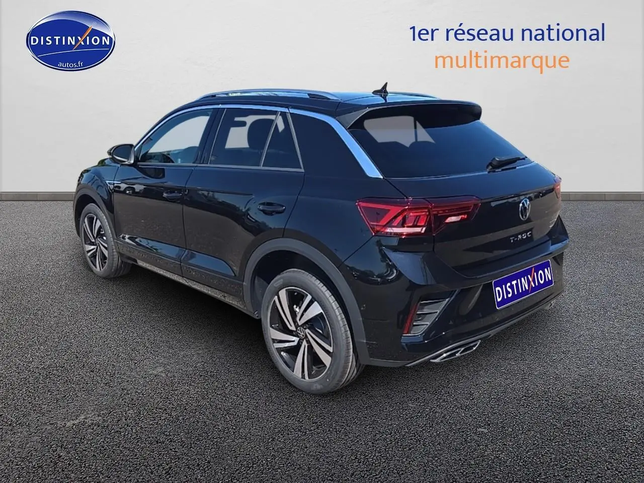 Volkswagen T-Roc noir perle en 3/4 arrière droit, avec jantes alliage 18 pouces et barres de toit argentées.