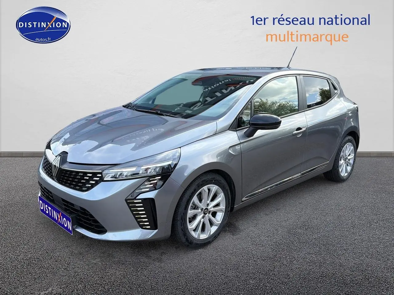 Renault Clio V gris en 3/4 avant droit, avec phares LED et jantes alliage 16 pouces visibles.