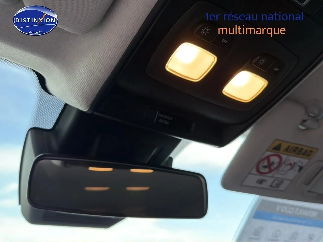 Vue intérieure du rétroviseur central et des plafonniers allumés d'une Renault Clio V gris 2025.