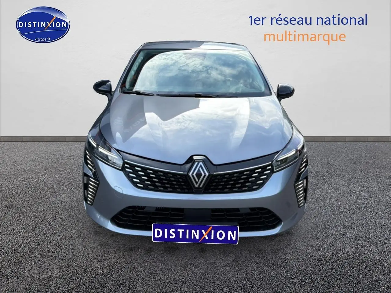 Vue avant d'une Renault Clio V gris métallisé avec calandre noire et feux LED verticaux allumés.