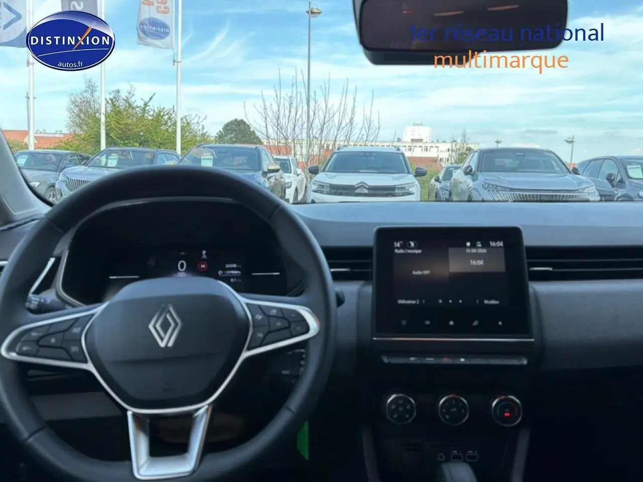 Vue intérieure centrée sur le volant multifonction et l’écran tactile du tableau de bord de la Renault Clio V gris 2025.