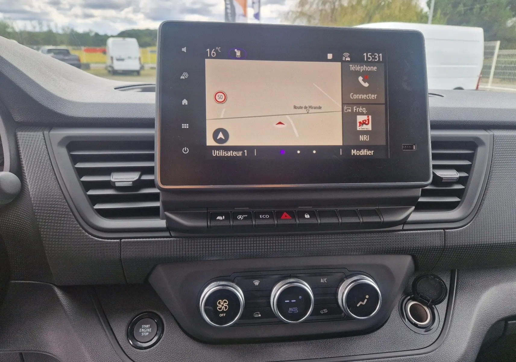 Tableau de bord du Renault Trafic Fourgon gris urbain 2025, avec écran tactile Easy Link et commandes de climatisation.