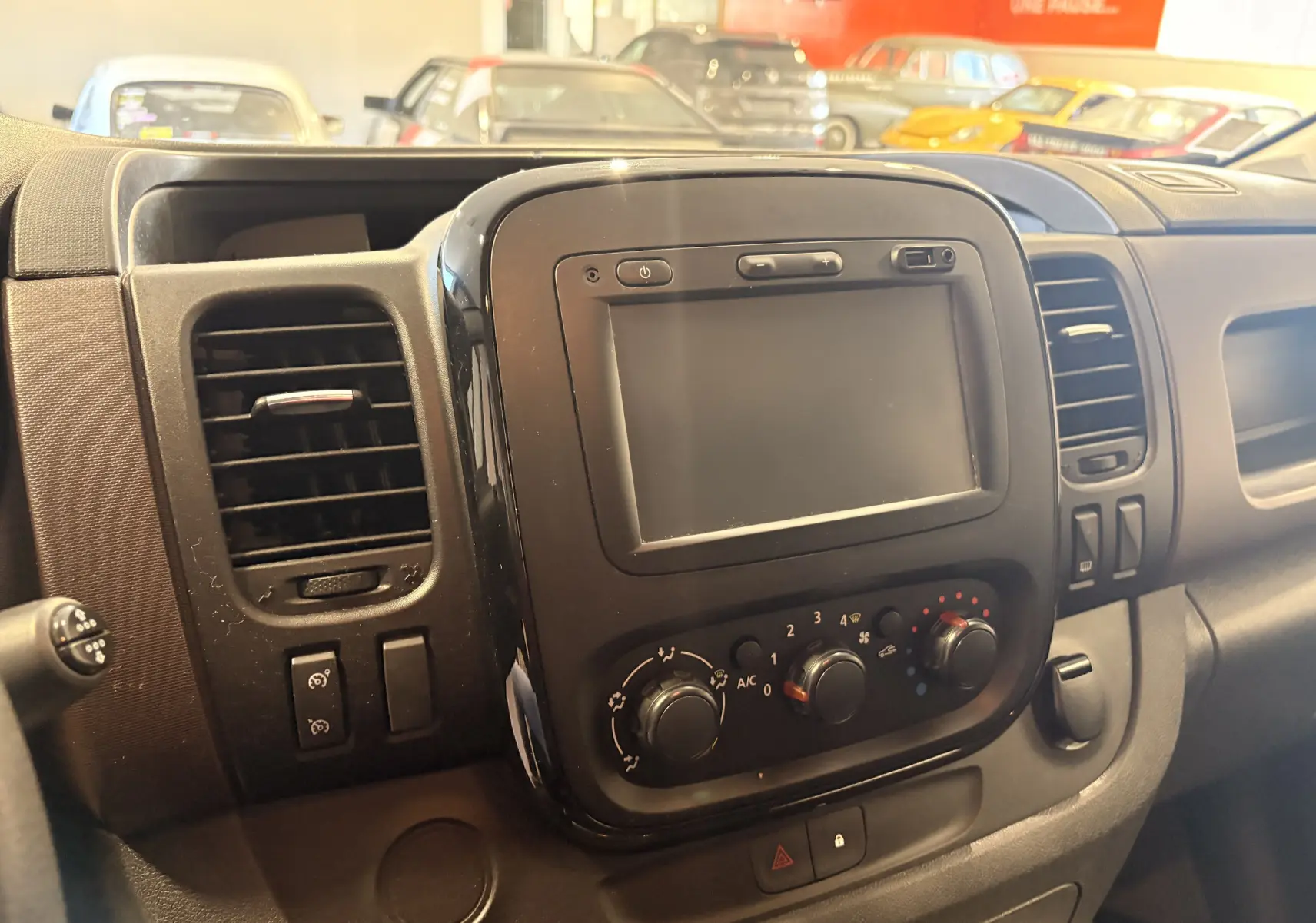 Vue rapprochée de la console centrale noire du Fiat Talento Fourgon gris, avec écran tactile et commandes de climatisation.