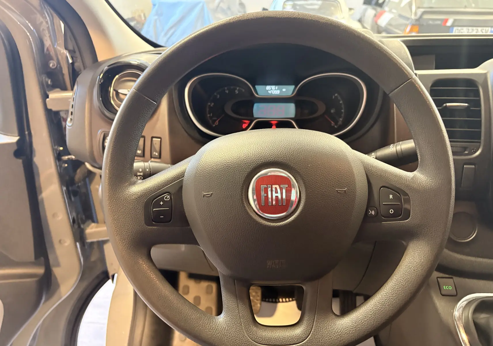 Vue intérieure centrée sur le volant noir du Fiat Talento Fourgon gris, avec tableau de bord et commandes visibles.