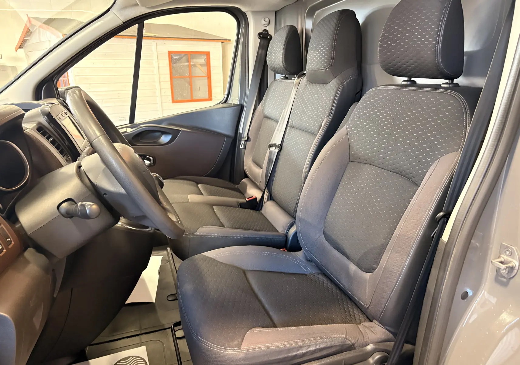 Vue intérieure côté conducteur du Fiat Talento Fourgon gris 2017, montrant les sièges tissu et le volant multifonction.