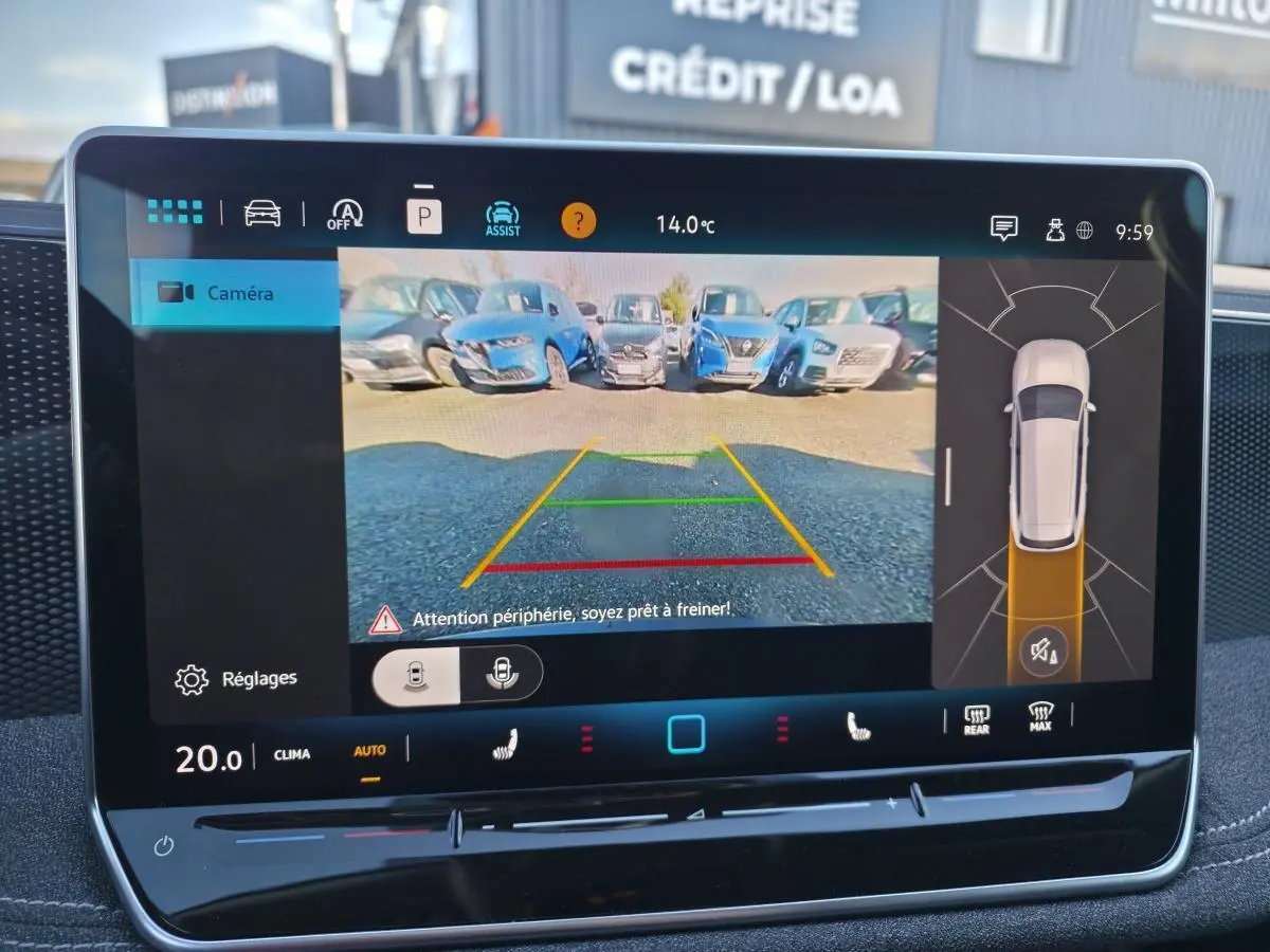 Vue de l'écran tactile intérieur affichant la caméra de recul et l'assistance au stationnement du Volkswagen Passat SW noir.