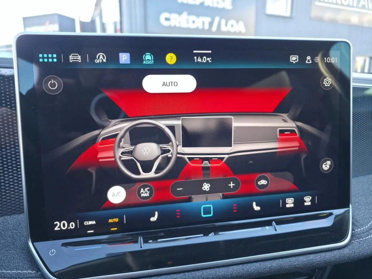 Écran tactile central affichant la climatisation automatique de la Volkswagen Passat SW 2024, intérieur noir avec détails rouges.