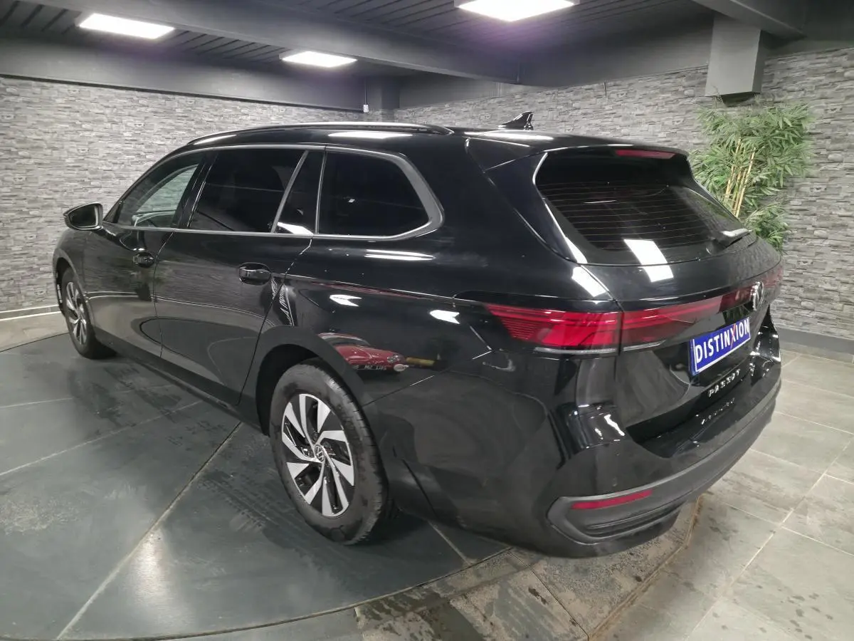 Volkswagen Passat SW noire vue 3/4 arrière droit, avec feux arrière LED et jantes alliage 16 pouces.
