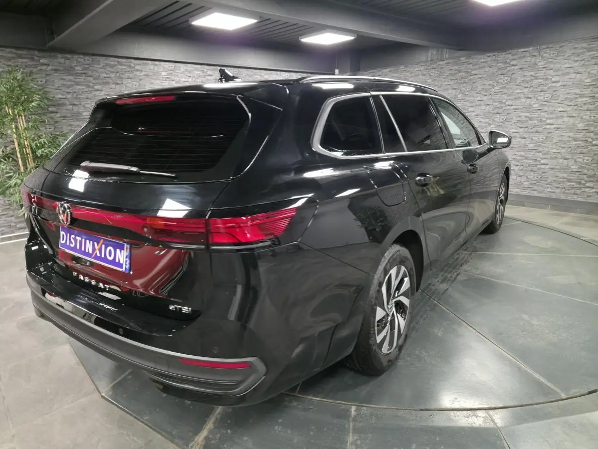 Vue 3/4 arrière droite d'un Volkswagen Passat SW noir métallisé, avec feux arrière LED et jantes alliage.