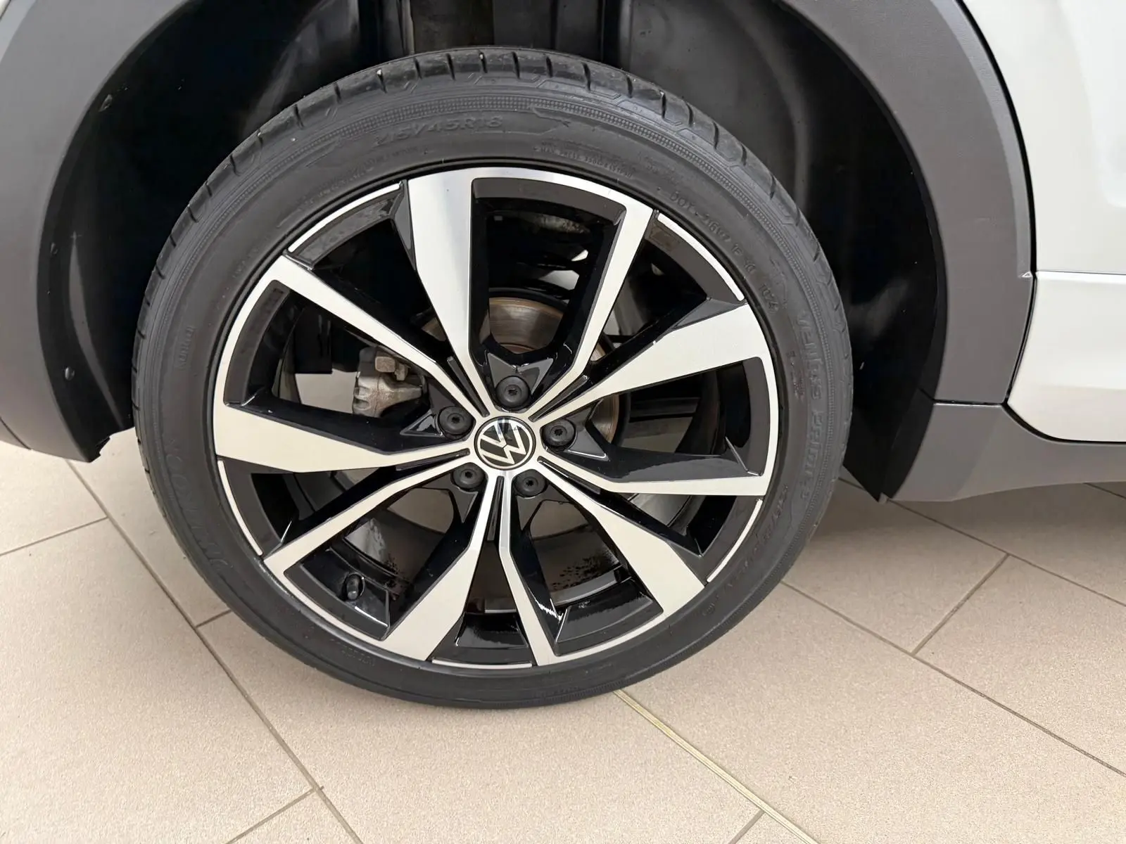 Gros plan sur la jante alliage 18 pouces bicolore noire et argent du Volkswagen T-Cross Reflet d'Argent côté droit.