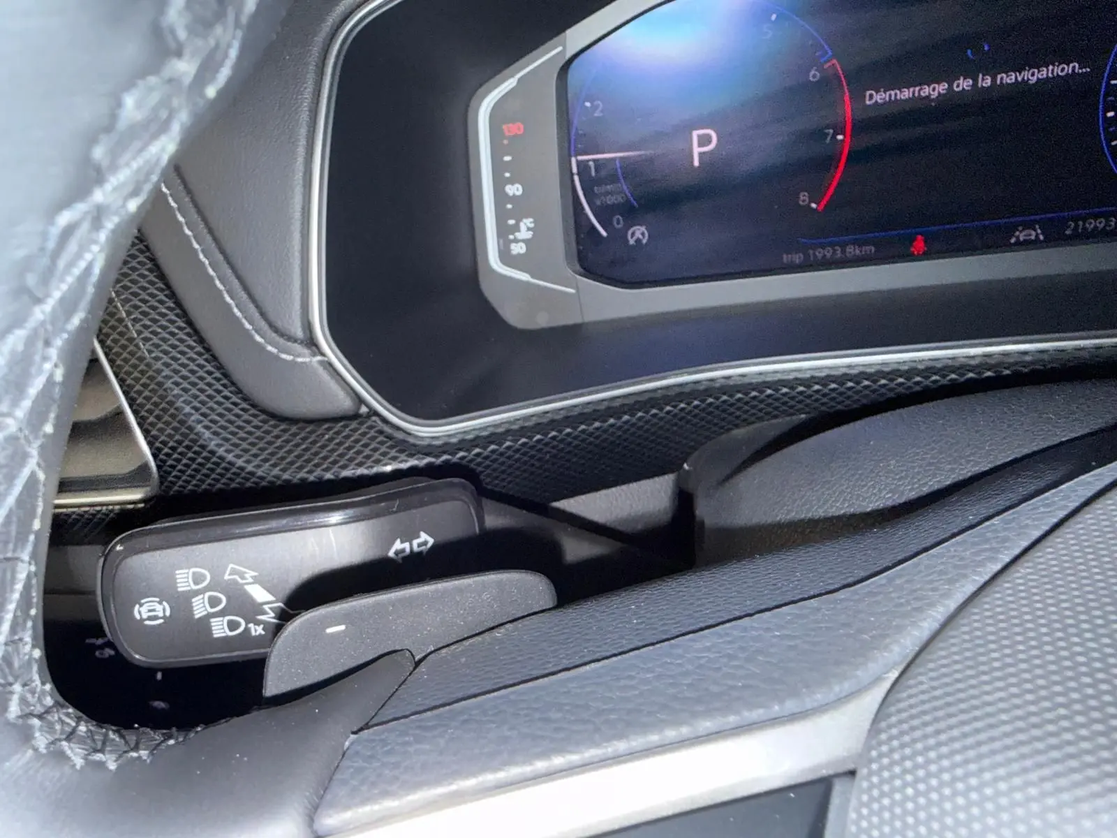 Gros plan sur le combiné d'instruments digital et la commande des feux du Volkswagen T-Cross 1.5 TSI R-Line, intérieur noir.