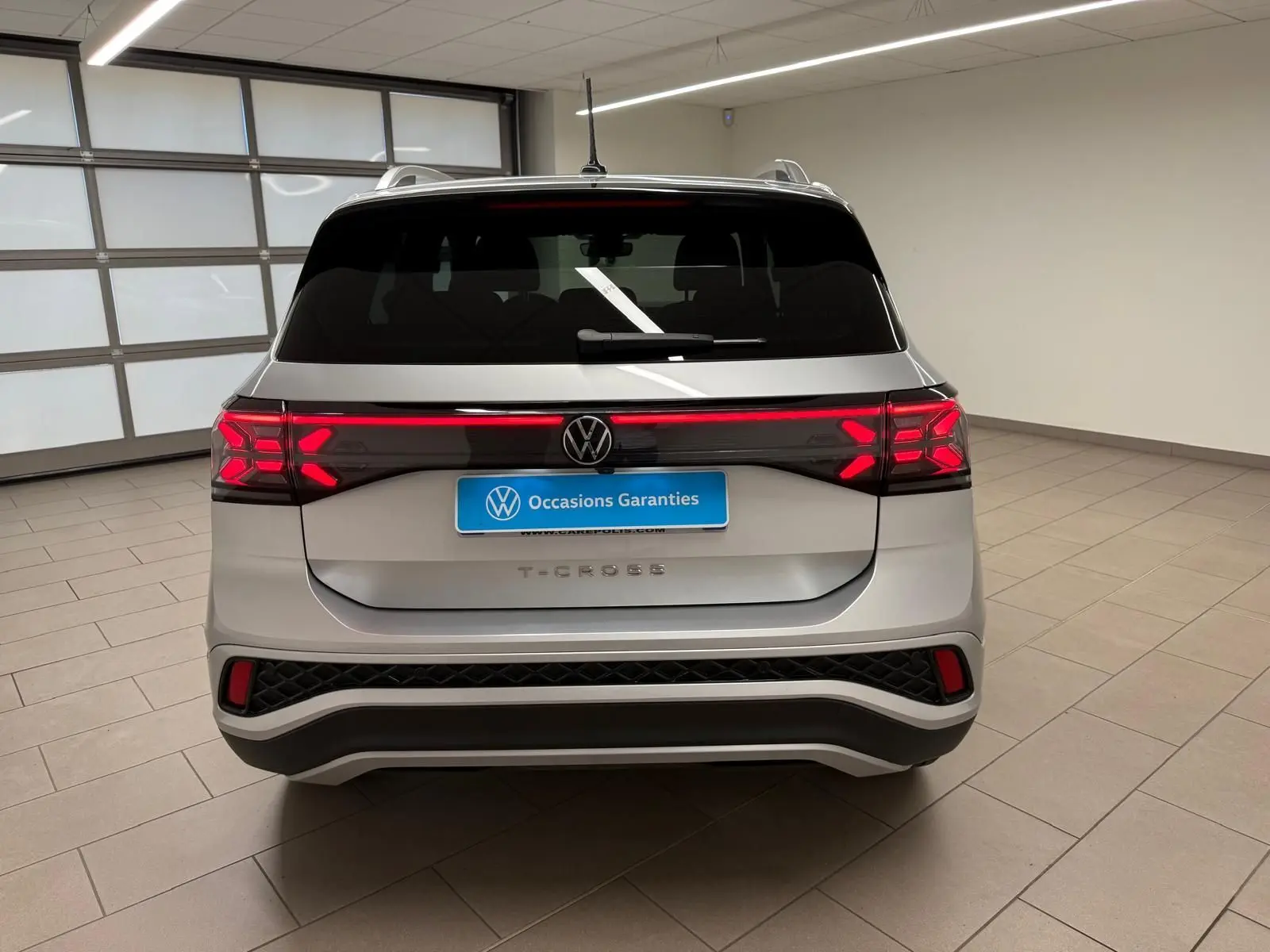 Vue arrière d'un Volkswagen T-Cross 1.5 TSI 150 DSG7 R-Line en couleur Reflet d'Argent avec feux LED allumés.