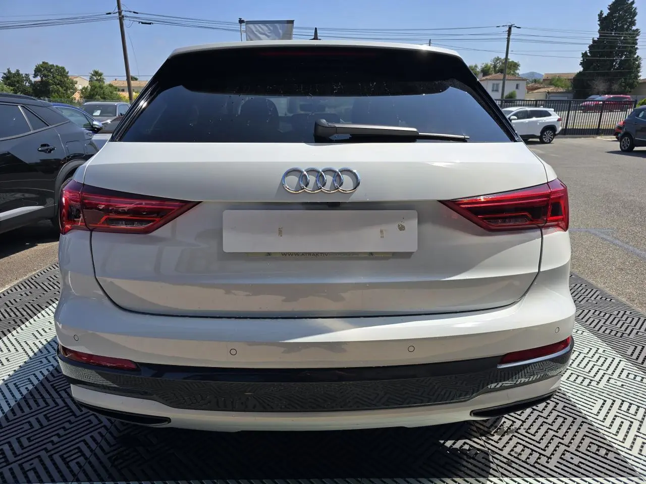 Vue arrière d’un Audi Q3 blanc 2022 avec vitres surteintées et feux LED distinctifs.
