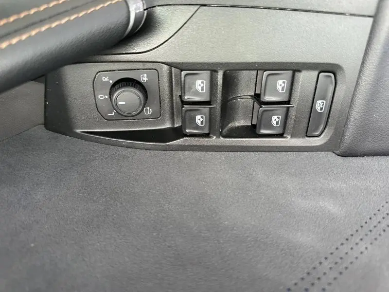 Gros plan sur les commandes des vitres et rétroviseurs côté conducteur du CUPRA Formentor blanc Nevada 2025.