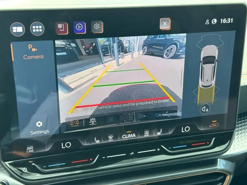 Écran tactile intérieur montrant la caméra de recul et l’aide au stationnement du CUPRA Formentor blanc Nevada.