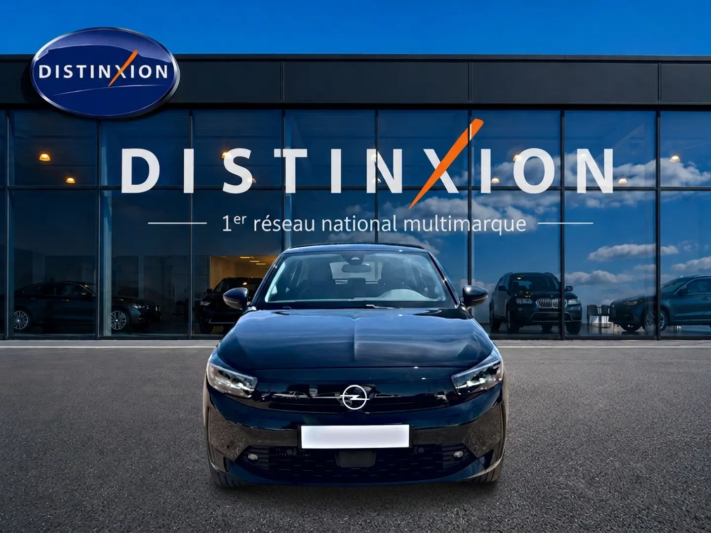 Opel Corsa 1.2 turbo 100 edition noire vue de face, avec calandre et phares LED devant un showroom Distinxion.