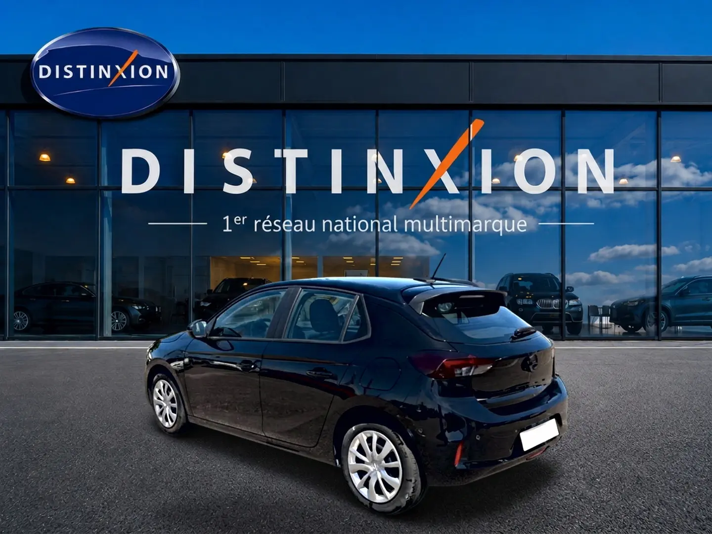 Opel Corsa 1.2 turbo 100 edition noire vue 3/4 arrière droit, avec becquet et jantes argentées.