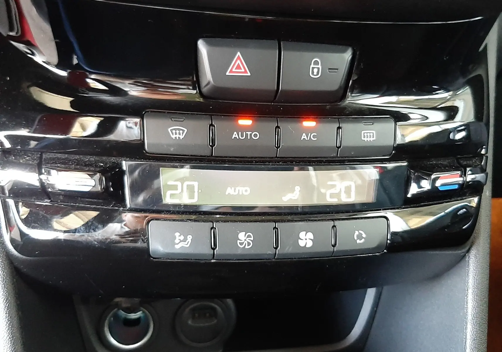 Gros plan sur la console centrale du Peugeot 2008 2019, affichant la climatisation automatique à 20°C.