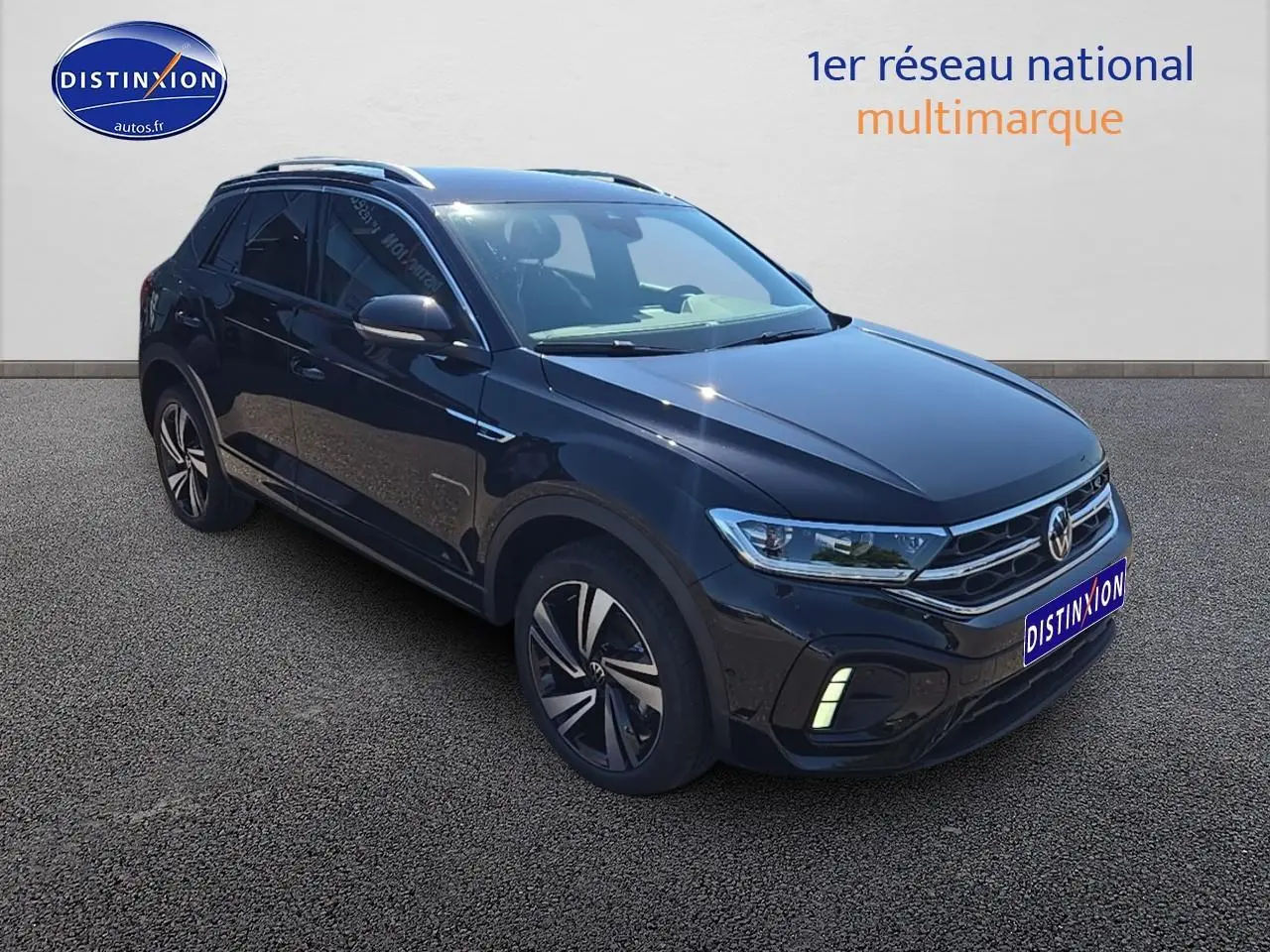 Volkswagen T-Roc noir perle en 3/4 avant droit avec jantes alliage et barres de toit argentées visibles.