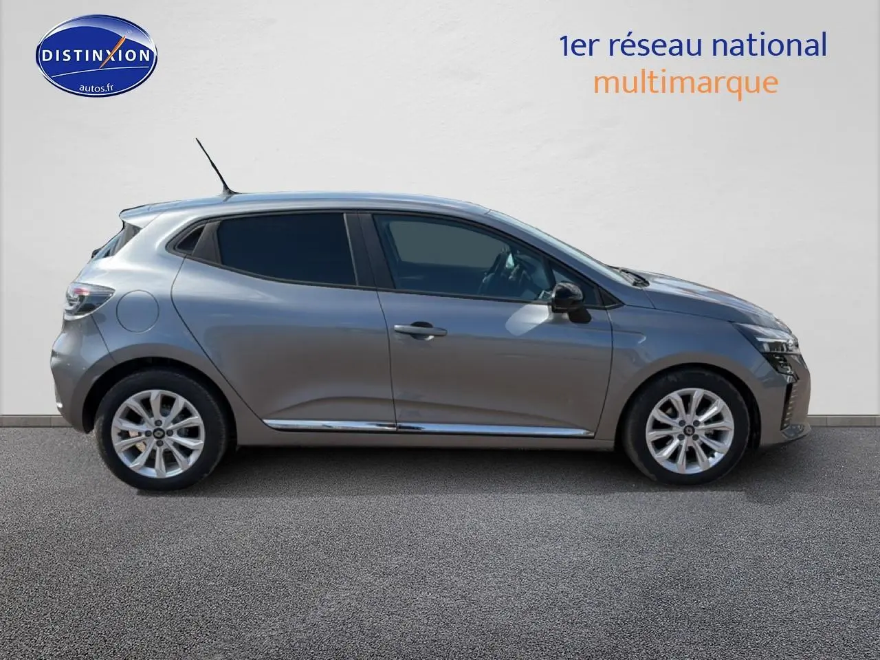 Profil droit d'une Renault Clio V gris foncé avec jantes alliage et vitres teintées sur fond neutre.