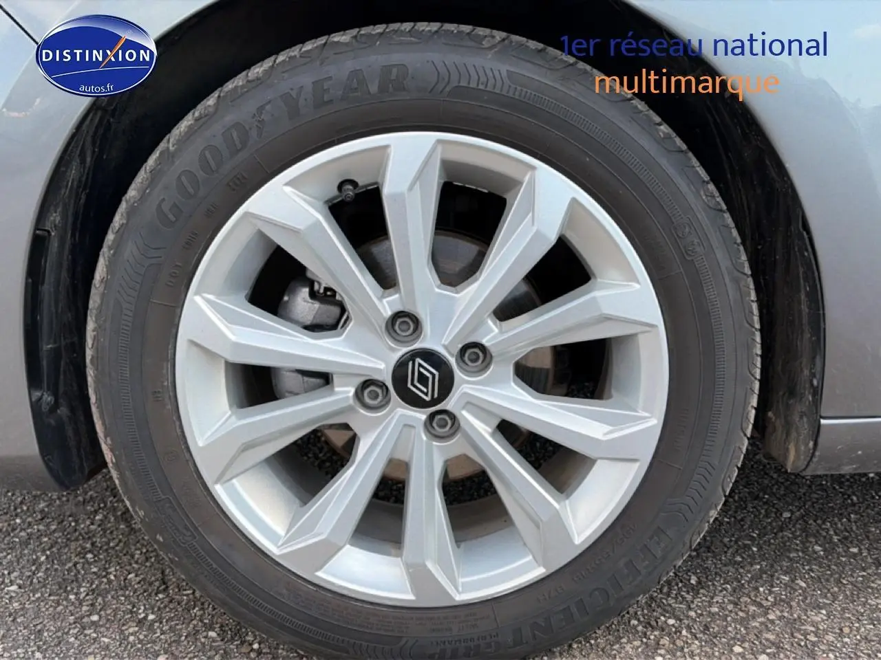 Gros plan sur la roue avant droite d'une Renault Clio V gris foncé avec jante alliage à plusieurs branches.