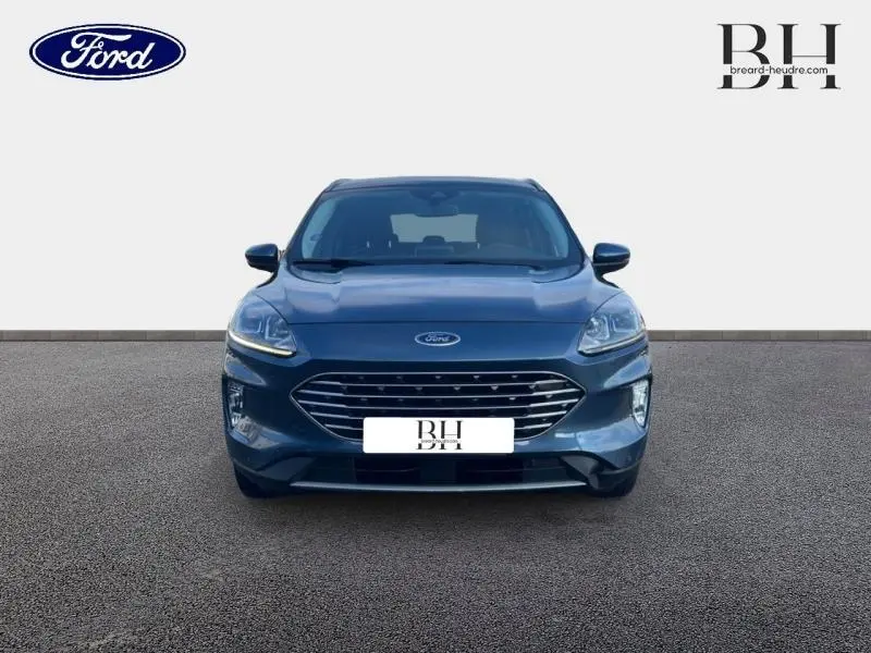 Vue frontale d'un Ford Kuga 2023 bleu azur métallisé avec calandre large et phares LED allumés.