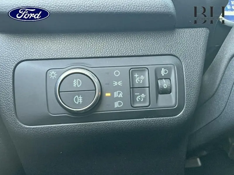 Gros plan sur les commandes d’éclairage intérieures du Ford Kuga 2023, avec réglages des phares et feux antibrouillard.