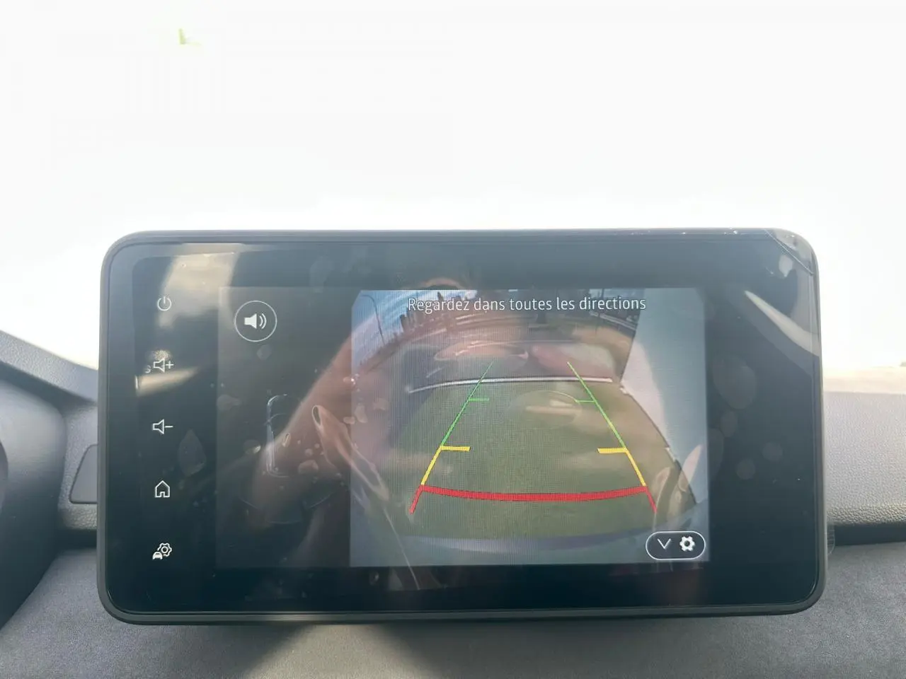 Écran tactile intérieur affichant la caméra de recul du Dacia Jogger hybride, avec repères de guidage colorés.