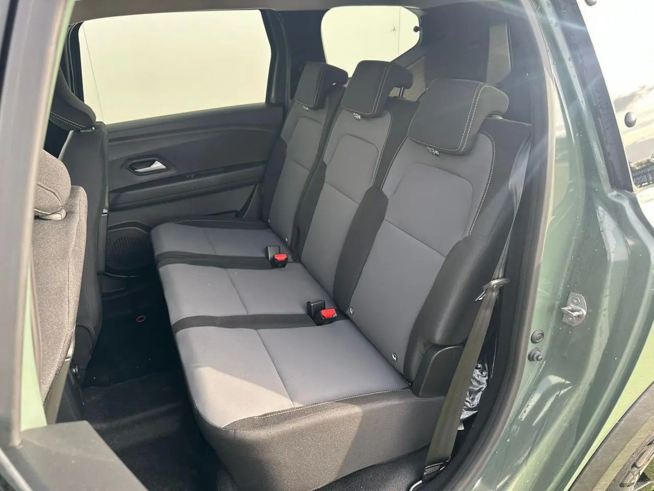 Vue intérieure côté droit sur la banquette arrière grise et noire du Dacia Jogger 2025 couleur kaki lichen métallisé.