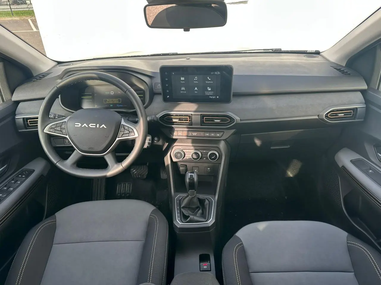 Vue intérieure frontale du tableau de bord et volant noir du Dacia Jogger 2025 avec écran tactile central.